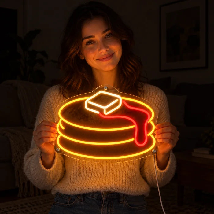 Pfannkuchen Neon LED Schild in den Händen einer lächelnden Frau vor dunklem Hintergrund