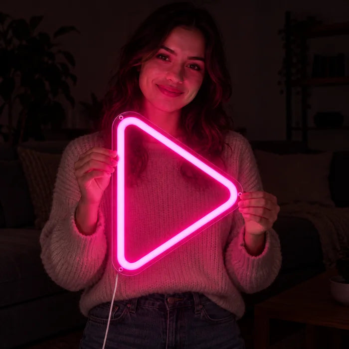 Play Neon LED Schild in den Händen einer lächelnden Frau vor dunklem Hintergrund