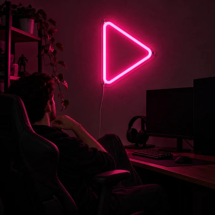 Play Neon LED Schild über dem Gaming-Schreibtisch, davor ein Spieler im Gaming-Stuhl