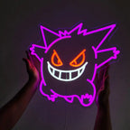 Lila Gengar Neon-Schild mit leuchtend roten/orangen Augen und weißem Mund, das von einer Person in einem dunklen Raum gehalten wird.