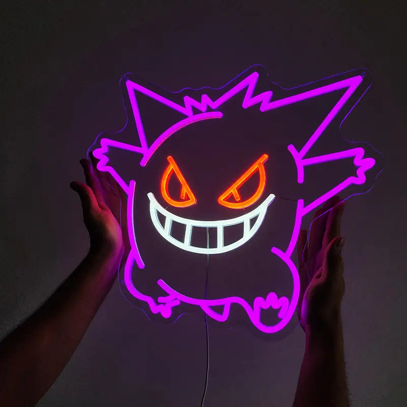 Lila Gengar Neon-Schild mit leuchtend roten/orangen Augen und weißem Mund, das von einer Person in einem dunklen Raum gehalten wird.