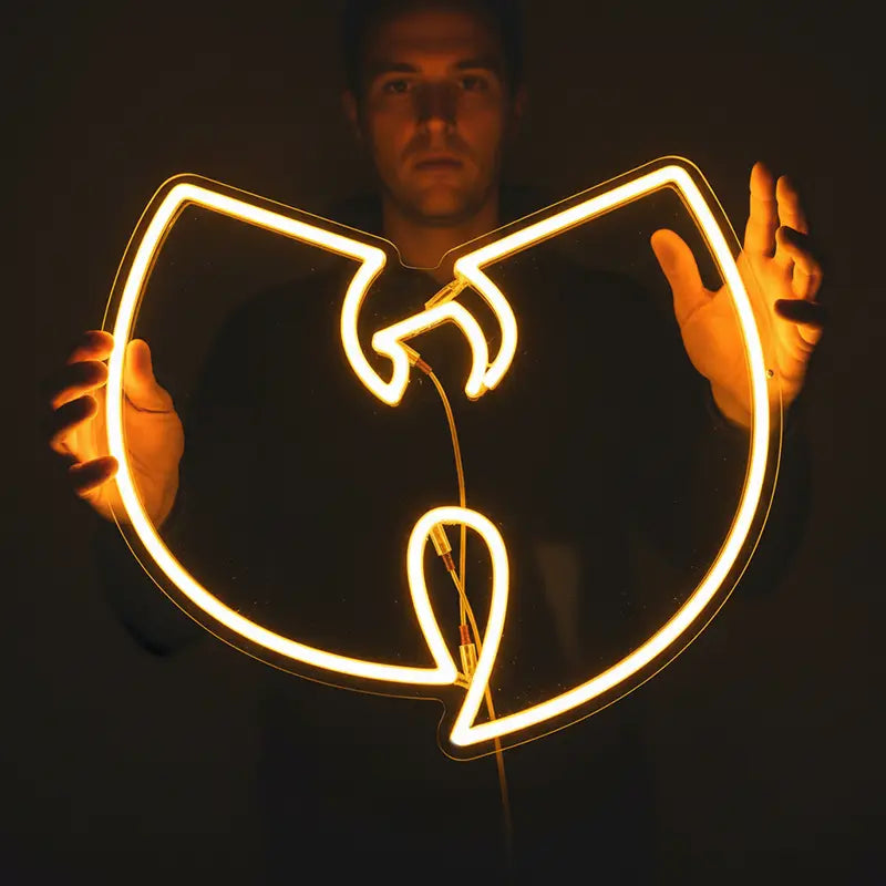 Orangefarbenes Neon-Logo in der Form des Wu-Tang Clan "W" auf schwarzer Halterung.
