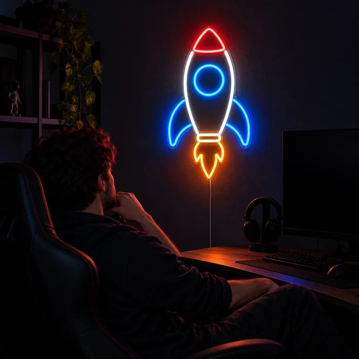 Retro-Rakete Neon LED Schild über dem Gaming-Schreibtisch, davor ein Spieler im Gaming-Stuhl