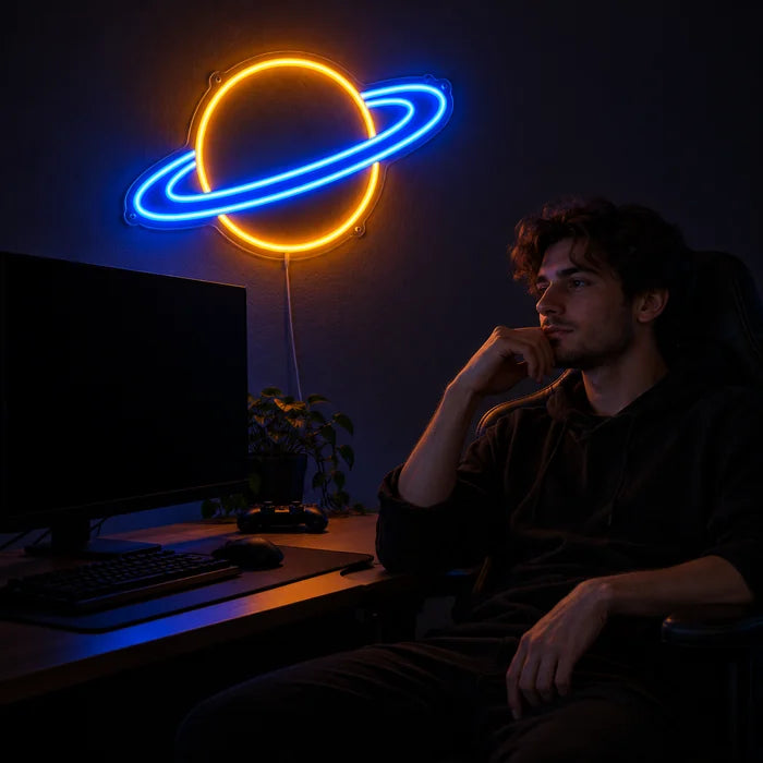 Ringplanet Neon LED Schild über dem Gaming-Schreibtisch, davor ein Spieler im Gaming-Stuhl