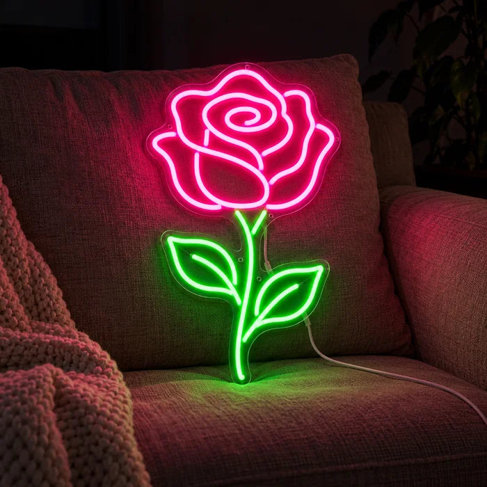 Rosenlicht Neon LED Schild auf einem gemütlichen Sofa zwischen Kissen und Decke