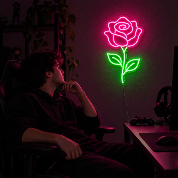 Rosenlicht Neon LED Schild über dem Gaming-Schreibtisch, davor ein Spieler im Gaming-Stuhl