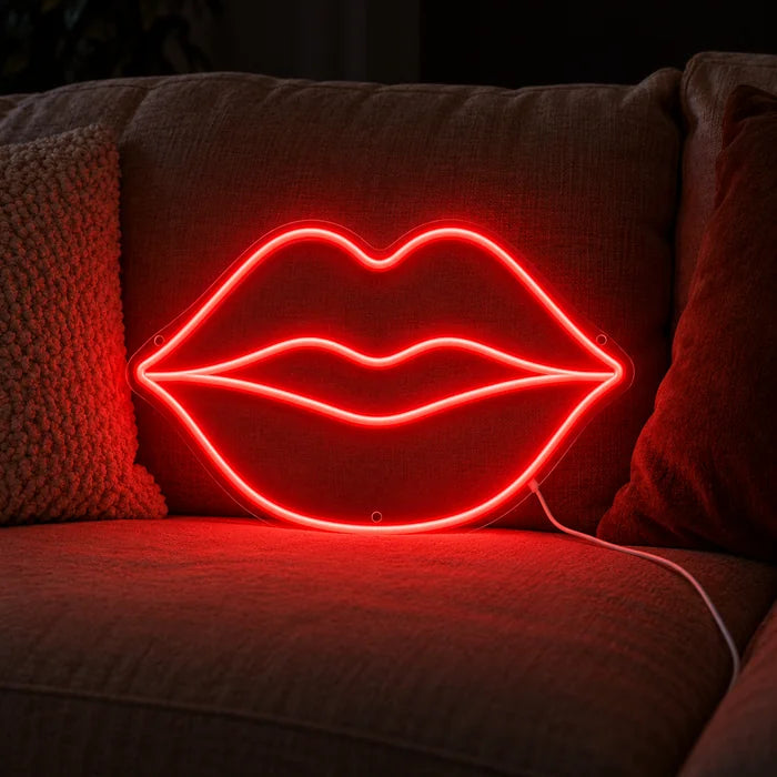 Rote Lippen Neon LED Schild auf einem gemütlichen Sofa zwischen Kissen und Decke