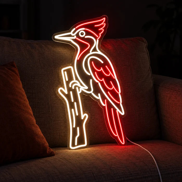 Roter Specht Neon LED Schild auf einem gemütlichen Sofa zwischen Kissen und Decke