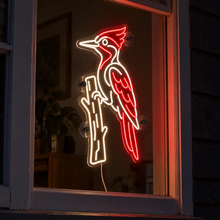 Roter Specht Neon LED Schild im Fenster, von der nächtlichen Straße aus gesehen