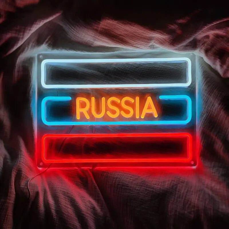 Nahaufnahme des Custom Neon Sign RUSSIA mit warmgelbem Licht und kühlen blauen/roten Außenrahmen