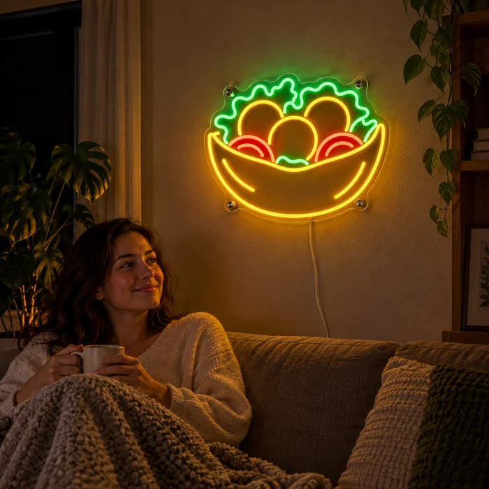 Salatschale Neon LED Schild an der Wohnzimmerwand, davor entspannt eine Person auf dem Sofa