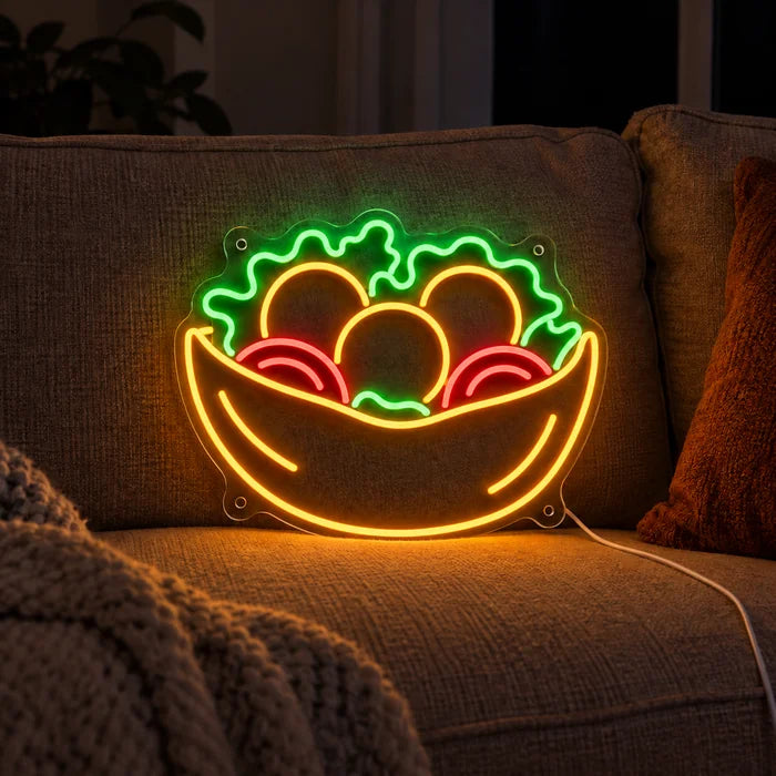 Salatschale Neon LED Schild auf einem gemütlichen Sofa zwischen Kissen und Decke
