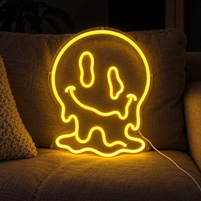 Schmelzender Schädel Neon LED Schild auf einem gemütlichen Sofa zwischen Kissen und Decke