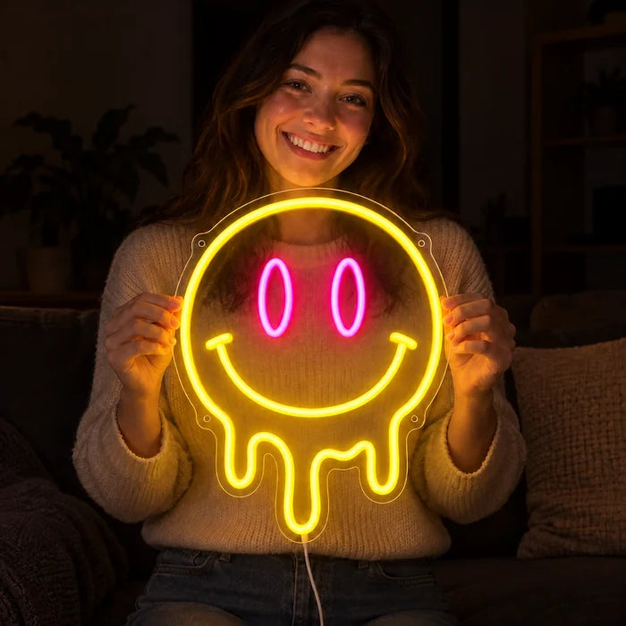 Schmelzender Smiley Neon LED Schild in den Händen einer lächelnden Frau vor dunklem Hintergrund