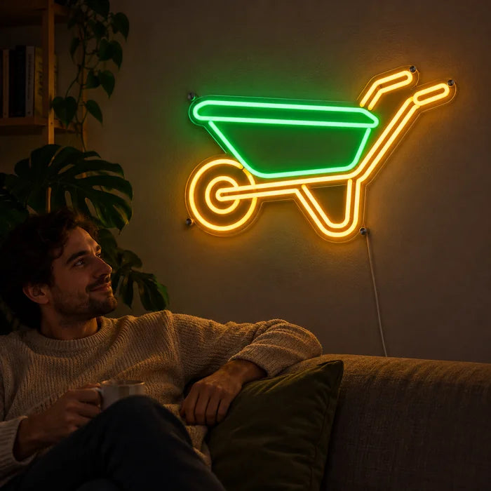 Schubkarre Neon LED Schild an der Wohnzimmerwand, davor entspannt eine Person auf dem Sofa