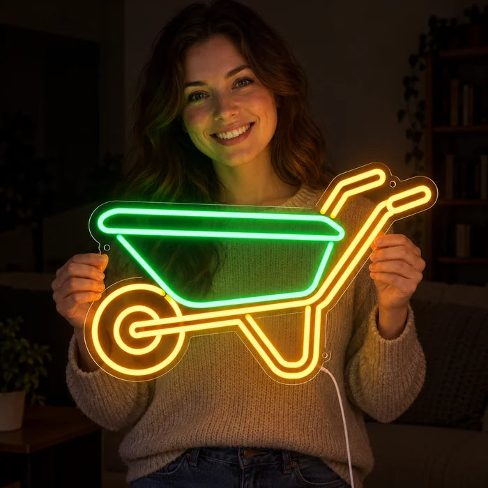 Schubkarre Neon LED Schild in den Händen einer lächelnden Frau vor dunklem Hintergrund