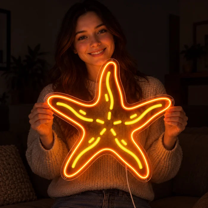 Seestern Neon LED Schild in den Händen einer lächelnden Frau vor dunklem Hintergrund