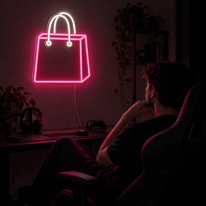 Shoppingtasche Neon LED Schild über dem Gaming-Schreibtisch, davor ein Spieler im Gaming-Stuhl