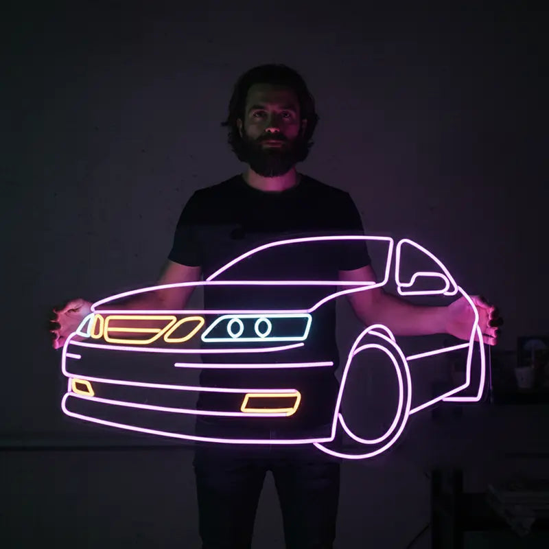 Neon-Umriss eines Saab 9-5 mit dem ikonischen geteilten Kühlergrill in warmem Gelb-Orange und runden Scheinwerfern in weiß