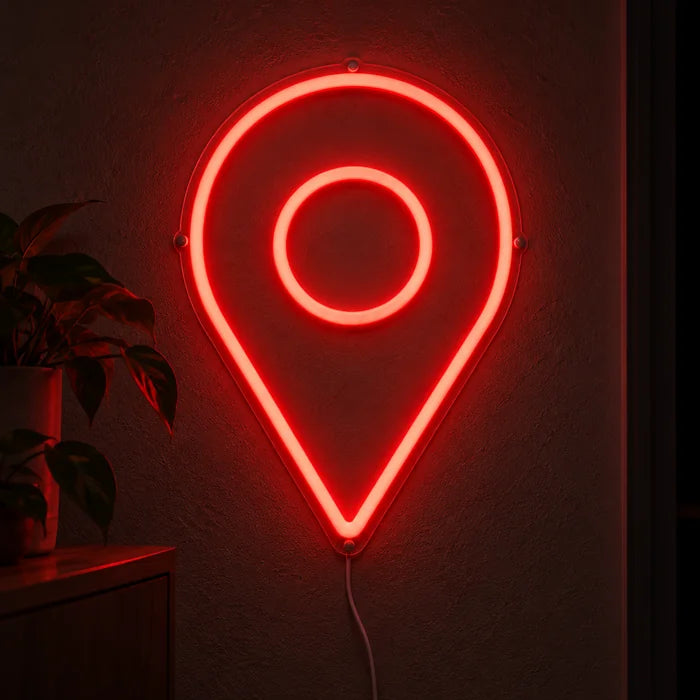 Standortmarker Neon LED Schild leuchtend an einer dunklen Wand, Nahaufnahme mit Anschlusskabel