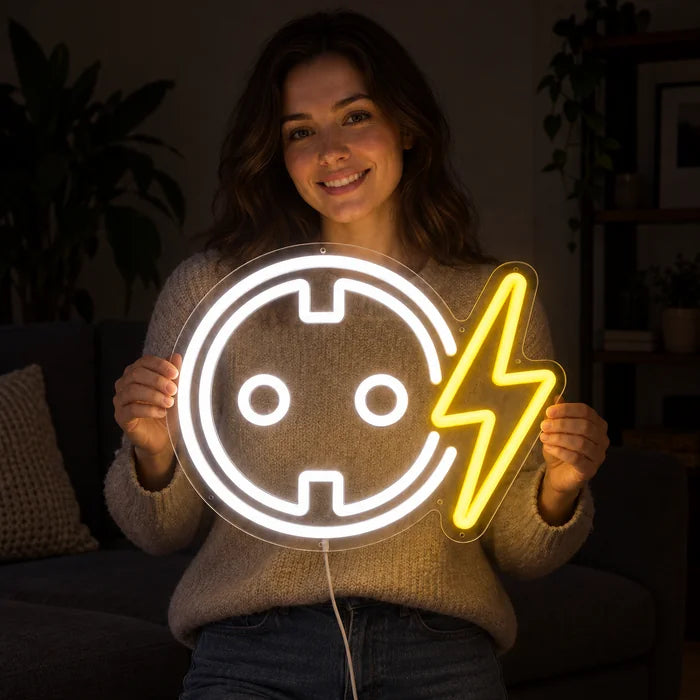 Steckdose mit Blitz Neon LED Schild in den Händen einer lächelnden Frau vor dunklem Hintergrund