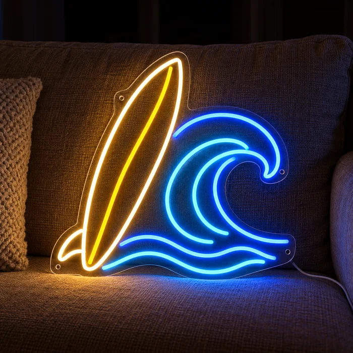 Surfbrett und Welle Neon LED Schild auf einem gemütlichen Sofa zwischen Kissen und Decke