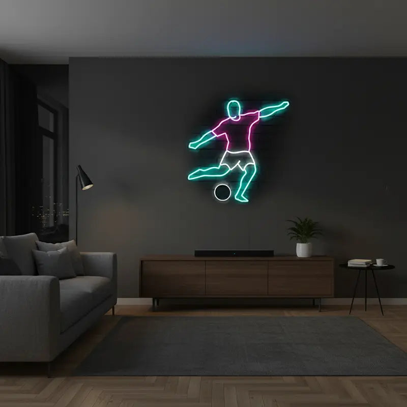 LED-Neon-Wanddeko eines Sportlers, der einen Ball tritt, beleuchtet in Pink und Cyan auf dunkler Ziegelwand.
