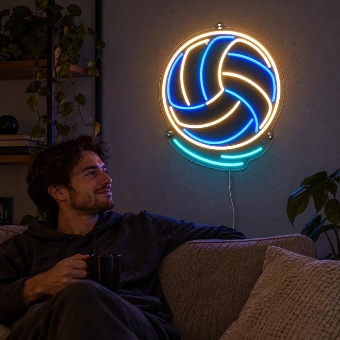 Volleyball Neon LED Schild an der Wohnzimmerwand, davor entspannt eine Person auf dem Sofa