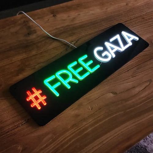 LED-Neon-Leuchtschrift auf schwarzer Platte mit dem Schriftzug FREE GAZA und einer roten Raute als Hashtag-Symbol.
