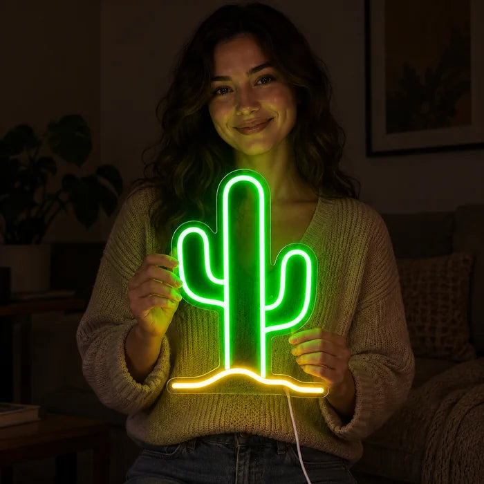 Wüstenkaktus Neon LED Schild in den Händen einer lächelnden Frau vor dunklem Hintergrund