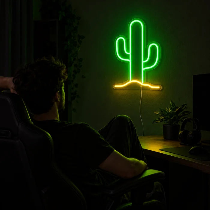 Wüstenkaktus Neon LED Schild über dem Gaming-Schreibtisch, davor ein Spieler im Gaming-Stuhl
