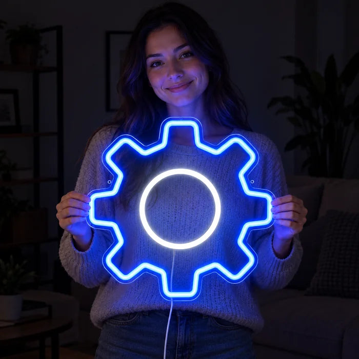 Zahnrad Neon LED Schild in den Händen einer lächelnden Frau vor dunklem Hintergrund